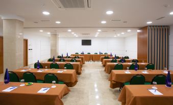 a large conference room with multiple tables and chairs arranged for a meeting or event at NH San Pedro