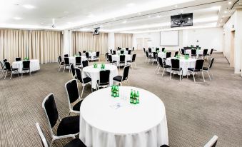 a large , empty banquet hall with round tables and chairs arranged for a conference or meeting at Park Inn by Radisson Krakow