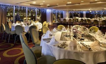 a large dining room with tables set for a formal dinner , featuring a variety of dishes and utensils at Park Plaza Leeds