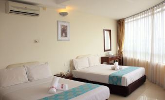 a hotel room with two beds , one on the left and one on the right side of the room at Sun Inns Hotel Kuala Selangor