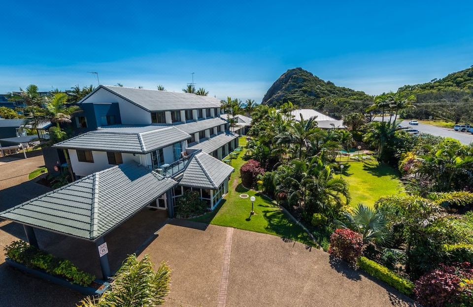 a bird 's eye view of a large house with a grassy yard and a mountain in the background at Rosslyn Bay Resort