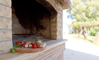 a pizza oven with a variety of food items on it , including pizzas and vegetables at Mila