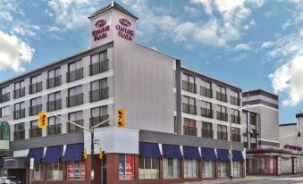 a large white building with a blue awning and a red sign on the side at Crowne Plaza Kitchener-Waterloo