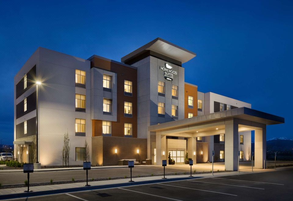 a modern hotel building with a large entrance and multiple floors , lit up at night at Homewood Suites by Hilton Salt Lake City Draper