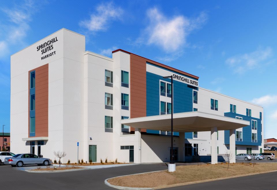 a large hotel building with a blue and white exterior , located on a street corner at SpringHill Suites Columbia