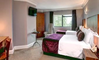 a hotel room with two beds , a window , and a tv , giving a cozy and elegant atmosphere at Best Western Plus Centurion Hotel