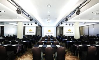 a conference room with rows of chairs arranged in a semicircle , and a podium at the front of the room at Hotel the One