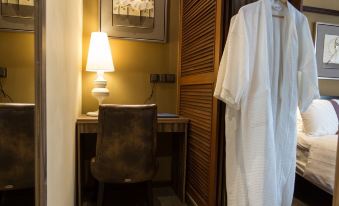 a hotel room with a bed , a desk , and a robe hanging on the door at Z Hotel