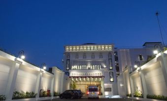 a large hotel with a red truck parked in front of it , illuminated by lights at Ayaartta Hotel Malioboro