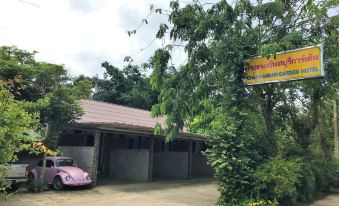 "a pink car is parked in front of a building with a sign that says "" phuong 's guest house .""." at Chanthaburi Garden Hotel