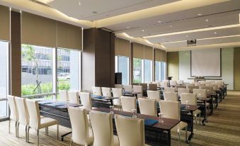 a large conference room with rows of chairs arranged in a semicircle , ready for a meeting or presentation at Novotel Taipei Taoyuan International Airport