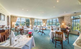 a large dining room with multiple tables and chairs arranged for a group of people to enjoy a meal together at Ees Wyke Country House
