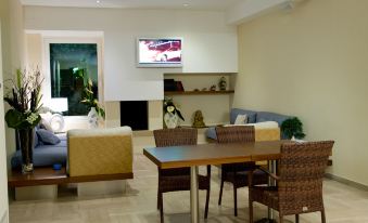 a modern living room with a dining area and a television mounted on the wall at Hotel Orsa Maggiore