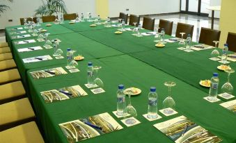 a long dining table set up for a meeting , with multiple chairs arranged around it at Hotel Flamingo