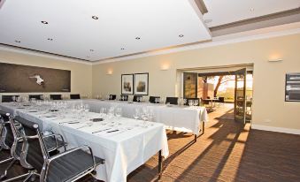 a large conference room with multiple long tables and chairs arranged for a meeting or event at The Louise