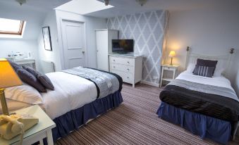 a cozy bedroom with two beds , one of which is a bunk bed , and a tv mounted on the wall at The Ascott