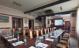 a large conference room with a long wooden table and multiple chairs arranged for a meeting at Hotel Victoria