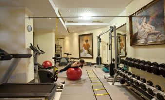 a woman is working out on a red exercise ball in a well - equipped home gym at Semeli Hotel