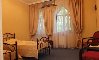 a bedroom with a bed , curtains , and a window , giving it a cozy and inviting atmosphere at Serebryanyy Bor