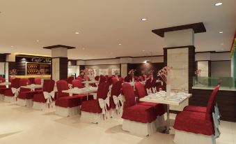 a large dining room with multiple tables and chairs , all covered in red tablecloths , creating a festive atmosphere at Hallmark Regency Hotel - Johor Bahru