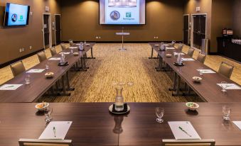 a conference room set up for a meeting , with multiple chairs arranged in a semicircle around a table at Holiday Inn Owensboro Riverfront