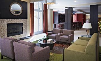 a modern living room with comfortable seating , a fireplace , and a large window overlooking the city at Holiday Inn Birmingham - Hoover