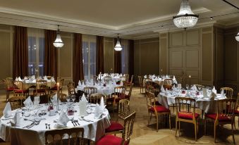 a large , elegant banquet hall with multiple dining tables set for a formal dinner or event at Grand Hotel la Cloche Dijon - MGallery
