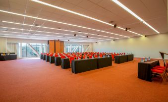 a large conference room with multiple rows of chairs and tables , all set up for a meeting or event at Exe Layos Golf
