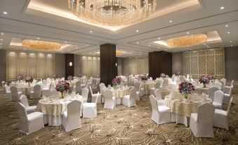 a large banquet hall with numerous tables covered in white tablecloths and chairs arranged for a formal event at Radisson Blu Gorakhpur