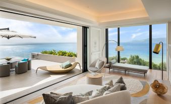 a modern living room with a large window overlooking the ocean , providing a scenic view at Halekulani Okinawa