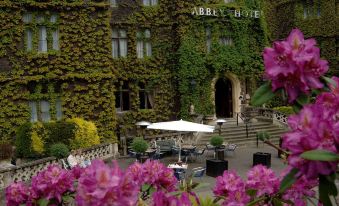 an outdoor dining area at the abbey hotel , with tables and chairs arranged for guests at The Abbey