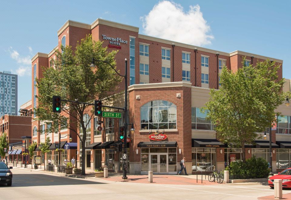 a city street with a brick building in the background , a shopping center in the foreground , and a restaurant on the corner at TownePlace Suites by Marriott Champaign
