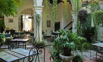 a courtyard with tables and chairs surrounded by potted plants , creating a relaxing atmosphere for outdoor dining at Valencia
