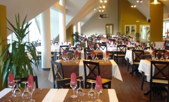 a large dining room filled with tables and chairs , ready for guests to enjoy a meal at Eira do Serrado - Hotel & Spa