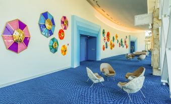 a colorful room with blue carpet , chairs , and colorful umbrellas on the walls , creating a vibrant atmosphere at Grand Hyatt Baha Mar