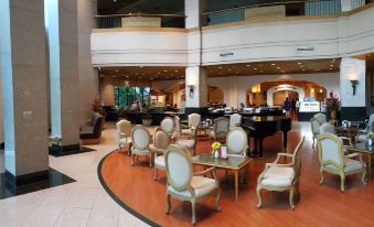 a spacious , well - lit lobby with multiple chairs and couches arranged around a coffee table in the center at Chon Inter Hotel