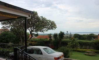 a white car is parked in a driveway near a house with a view of the ocean at Victoria Guest House