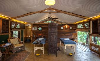 a room with wooden walls and a ceiling has two ping pong tables in the center at The Machan