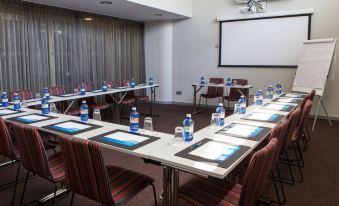 a conference room set up for a meeting , with chairs arranged in rows and a projector on the wall at Radisson Blu Resort, Gran Canaria