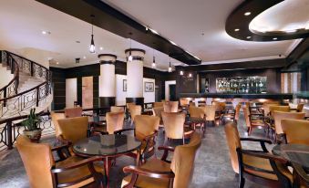 a large dining room with numerous tables and chairs arranged for a group of people at Aston Karimun City Hotel