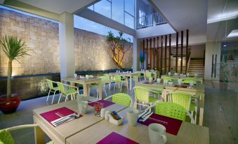 a dining room with tables and chairs arranged for a group of people to enjoy a meal together at favehotel Langko Mataram - Lombok