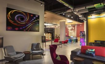 a modern living room with colorful furniture , including couches and chairs , creating a vibrant atmosphere at Aloft Coral Gables