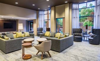 a modern hotel lobby with several couches and chairs arranged in a lounge - like setting , creating a comfortable atmosphere for guests at Courtyard Danbury
