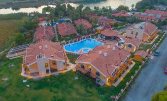 aerial view of a large resort with multiple buildings , a swimming pool , and a lake in the background at Dalyan Live Spa Hotel