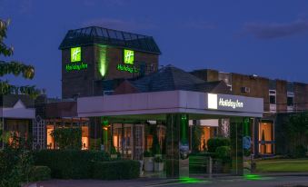 "the exterior of a hotel with a green and white sign that reads "" holiday inn ""." at Holiday Inn Leeds - Garforth