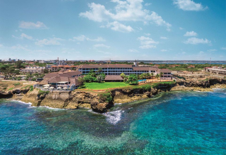 an aerial view of a resort near the ocean , featuring multiple buildings and a large pool at Sea Cliff Hotel