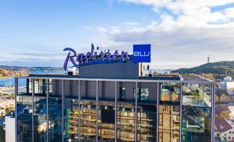 "a large building with a blue sign that reads "" radisson blu "" on top of it" at Radisson Blu Caledonien Hotel, Kristiansand