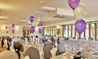 a large banquet hall filled with tables and chairs , where a wedding reception is taking place at Best Western Bradford Guide Post Hotel