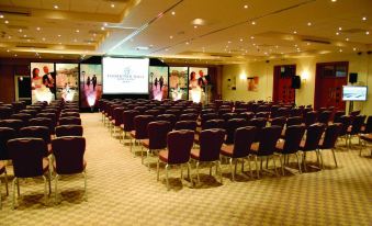 a large conference room filled with rows of chairs , ready for an event or meeting at Thornton Hall Hotel & Spa