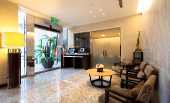 a modern lobby with marble flooring , chairs , and potted plants , as well as a reception desk at Sol Hotel